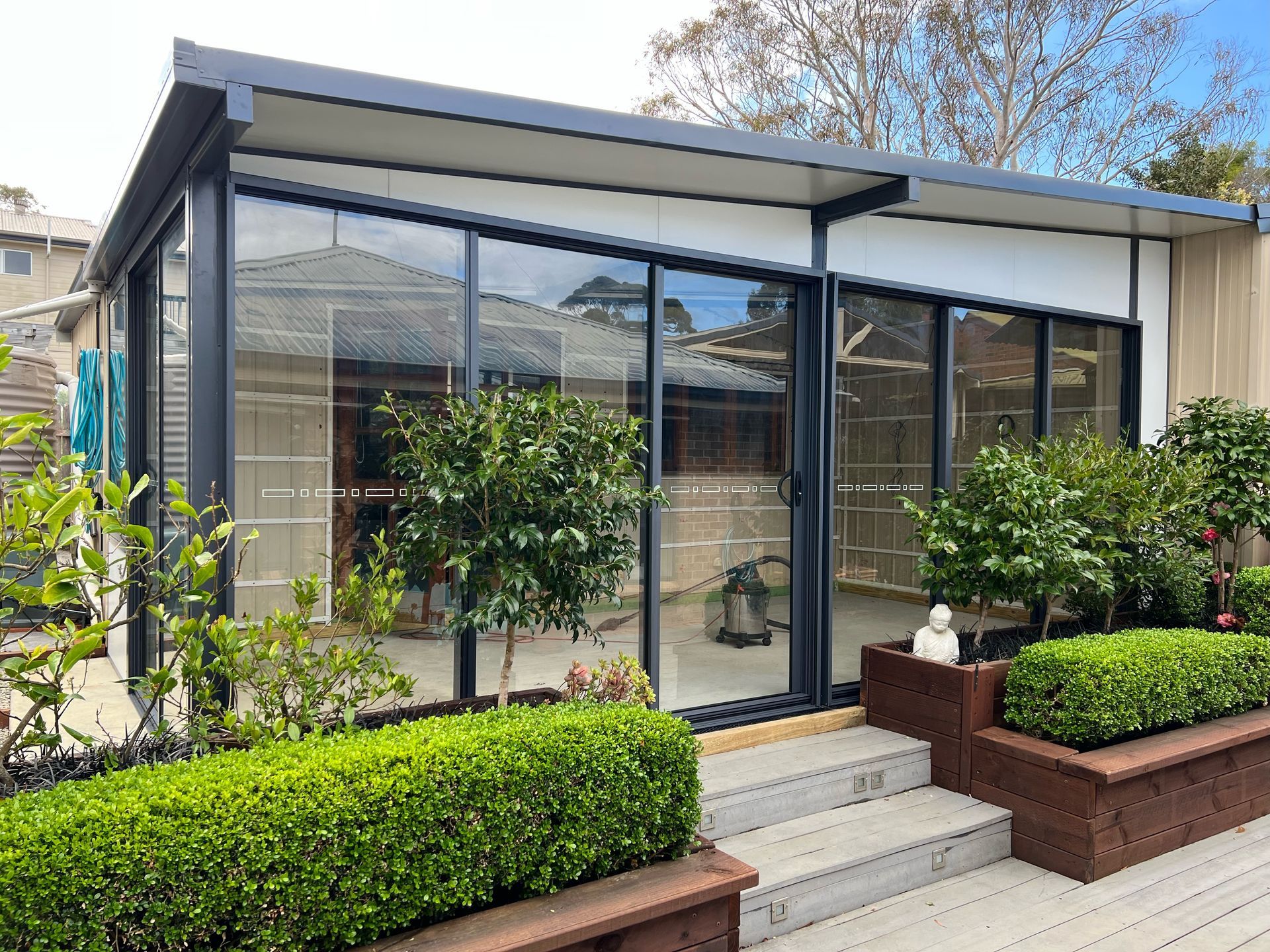 A white patio cover is being installed on the side of a brick house.