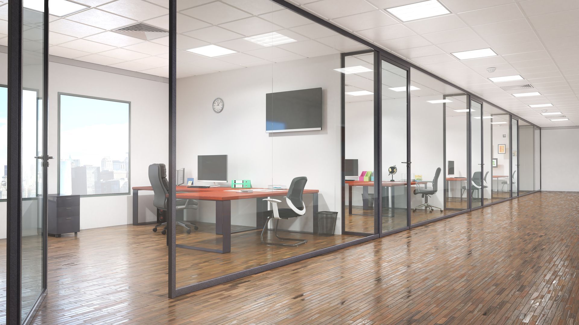Modern office interior with multiple glass-walled cubicles, sleek desks, chairs, and wood flooring under ceiling lights.