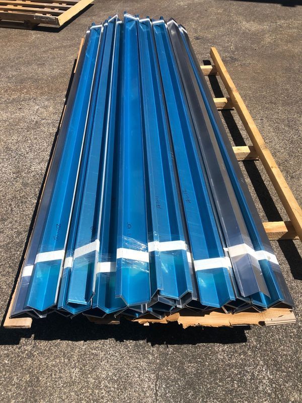A stack of blue metal sheets sitting on top of a wooden pallet.
