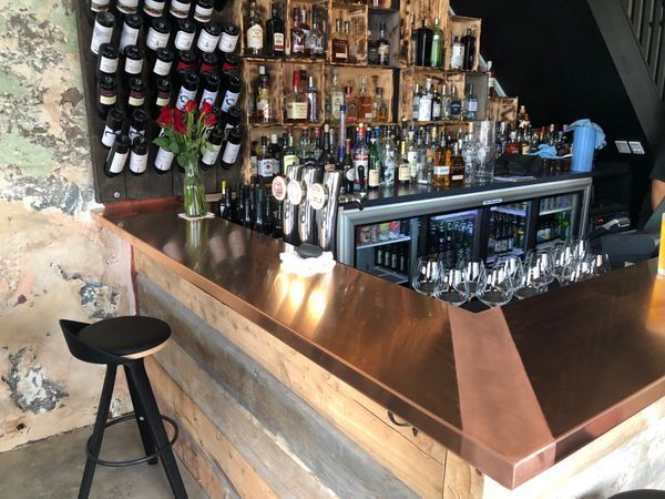 A bar with a lot of bottles of alcohol on it.