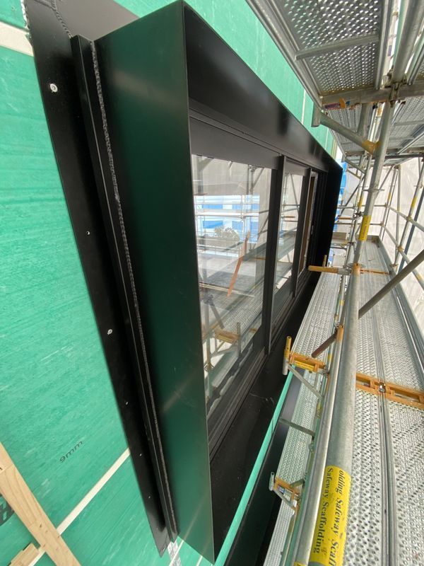 A building under construction with scaffolding and a large window.