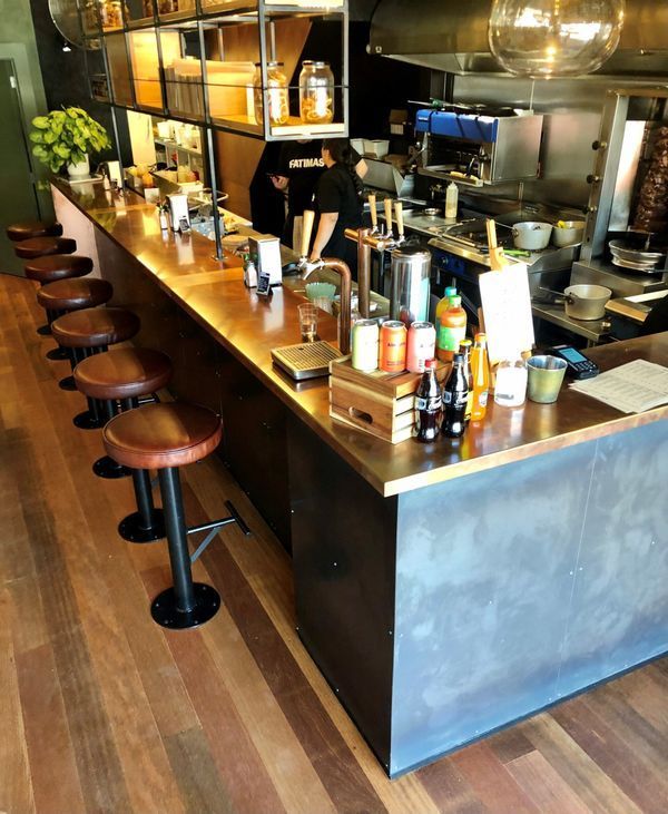 A restaurant with a long counter and stools.