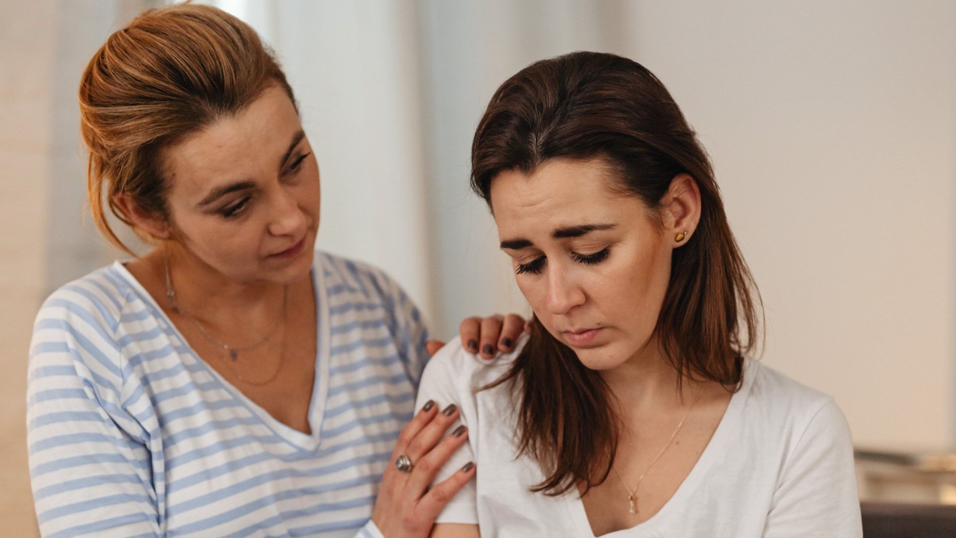sad woman being comforted by another