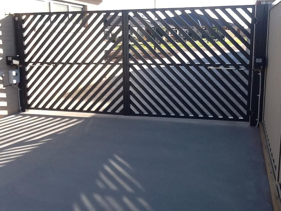 A Black Striped Gate With A Shadow On The Ground – East Gippsland, VIC - East Gippsland Garage Doors & Maintenance