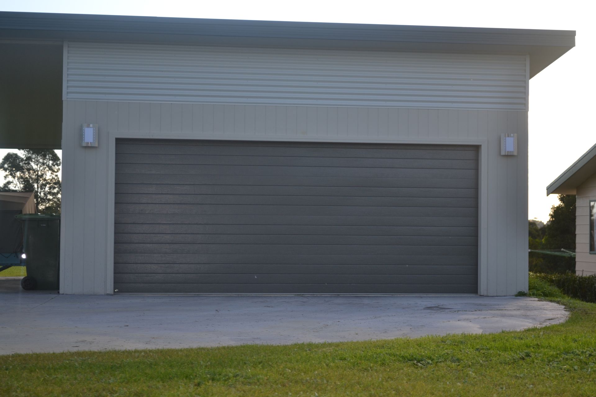 A Wooden Garage Door Is Sitting In Front Of A White House – East Gippsland, VIC - East Gippsland Garage Doors & Maintenance