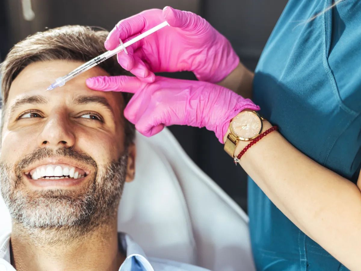 Profissional aplicando preenchedores faciais em um paciente.