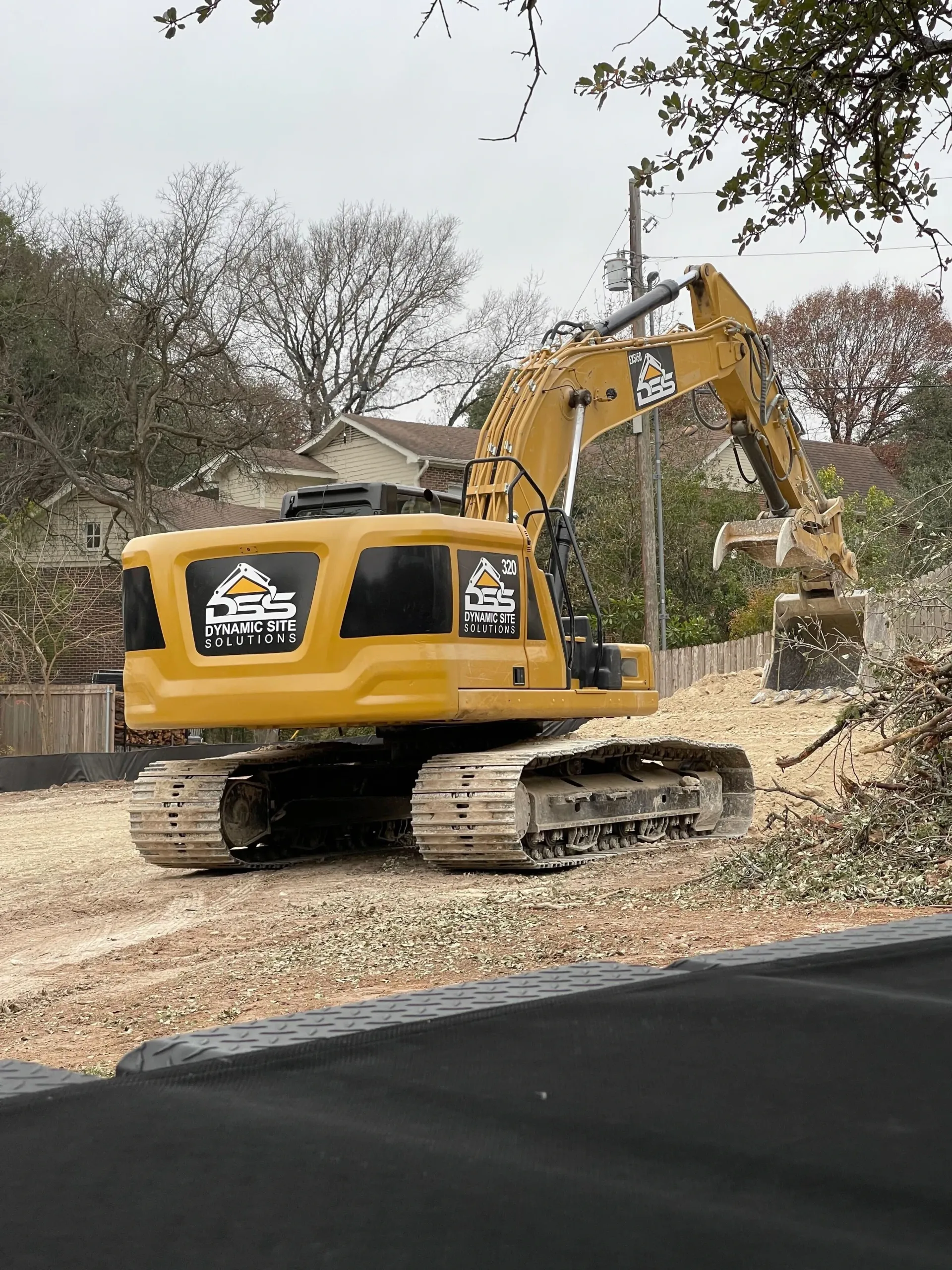 A construction vehicle is driving down a dirt road.