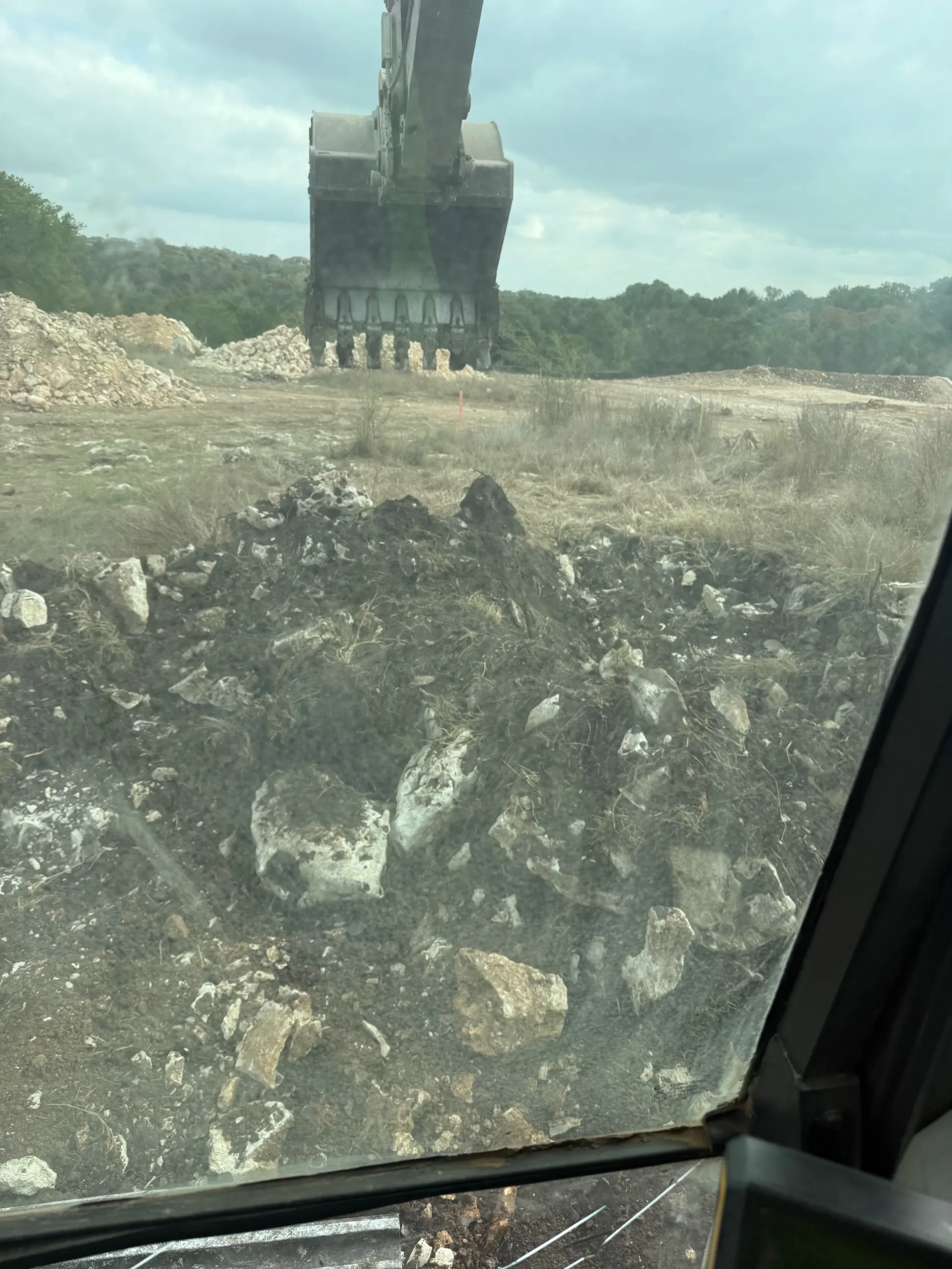 A yellow excavator is digging a hole in the ground.