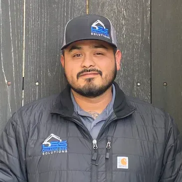 A man with a beard is wearing a hat and a jacket.