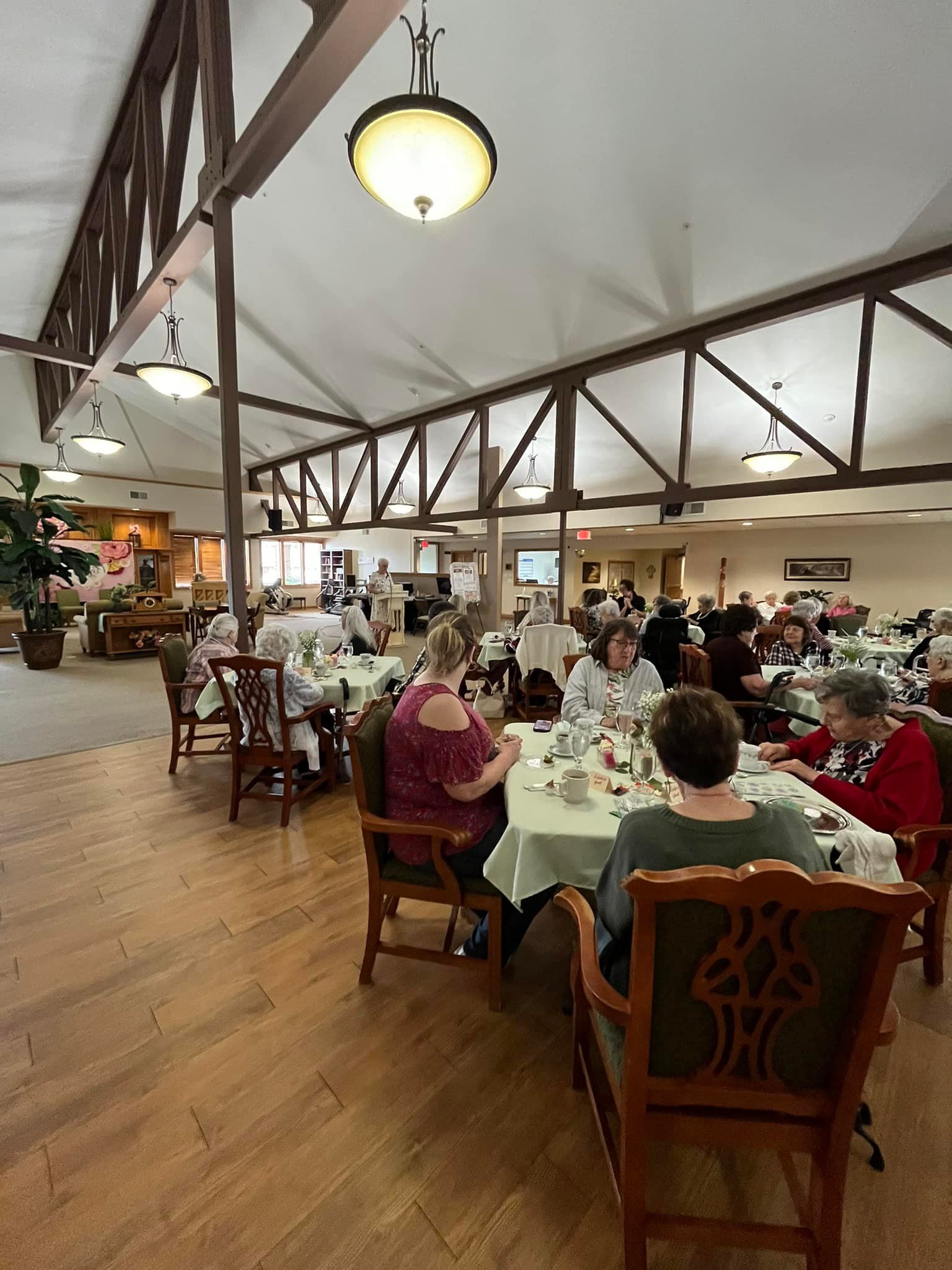 Gazebo in a landscaped garden with a brick building in the background.