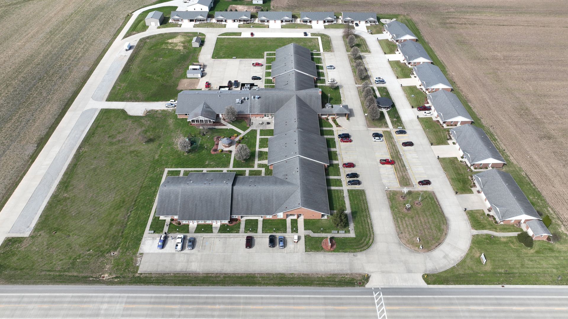 Porch of a brick building with a metal table and chairs, a star, and potted plants.