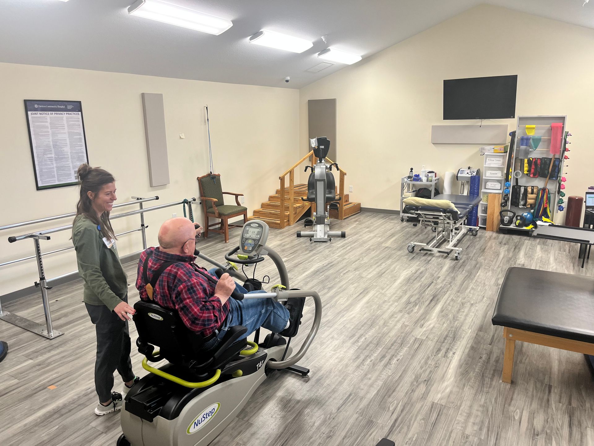 Rainbow arches over a residential area with a brick building and parked cars.
