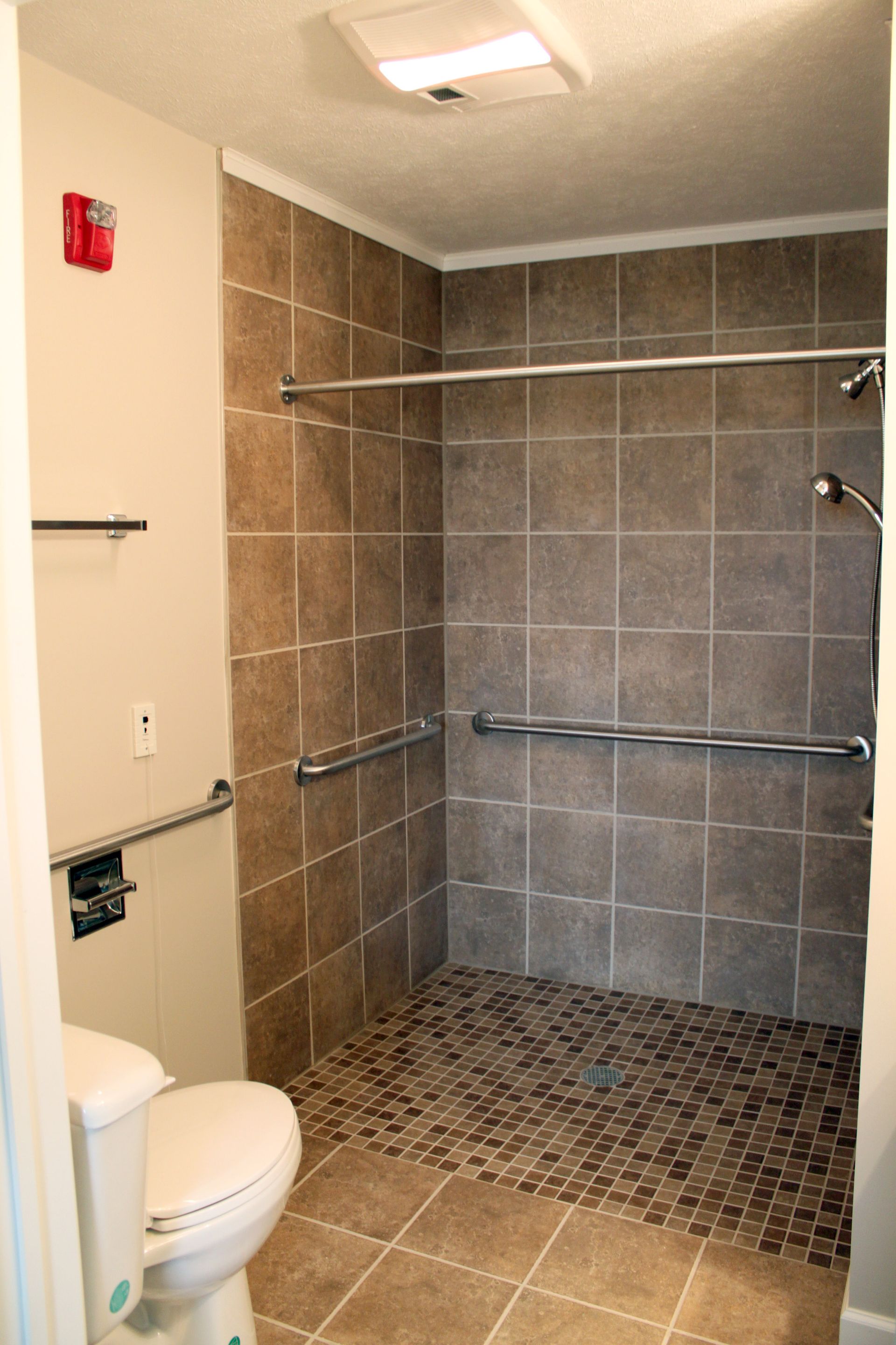 Gazebo in a landscaped garden with a brick building in the background.