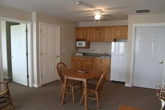 Small apartment with a kitchen, round table and chairs, and two doors.