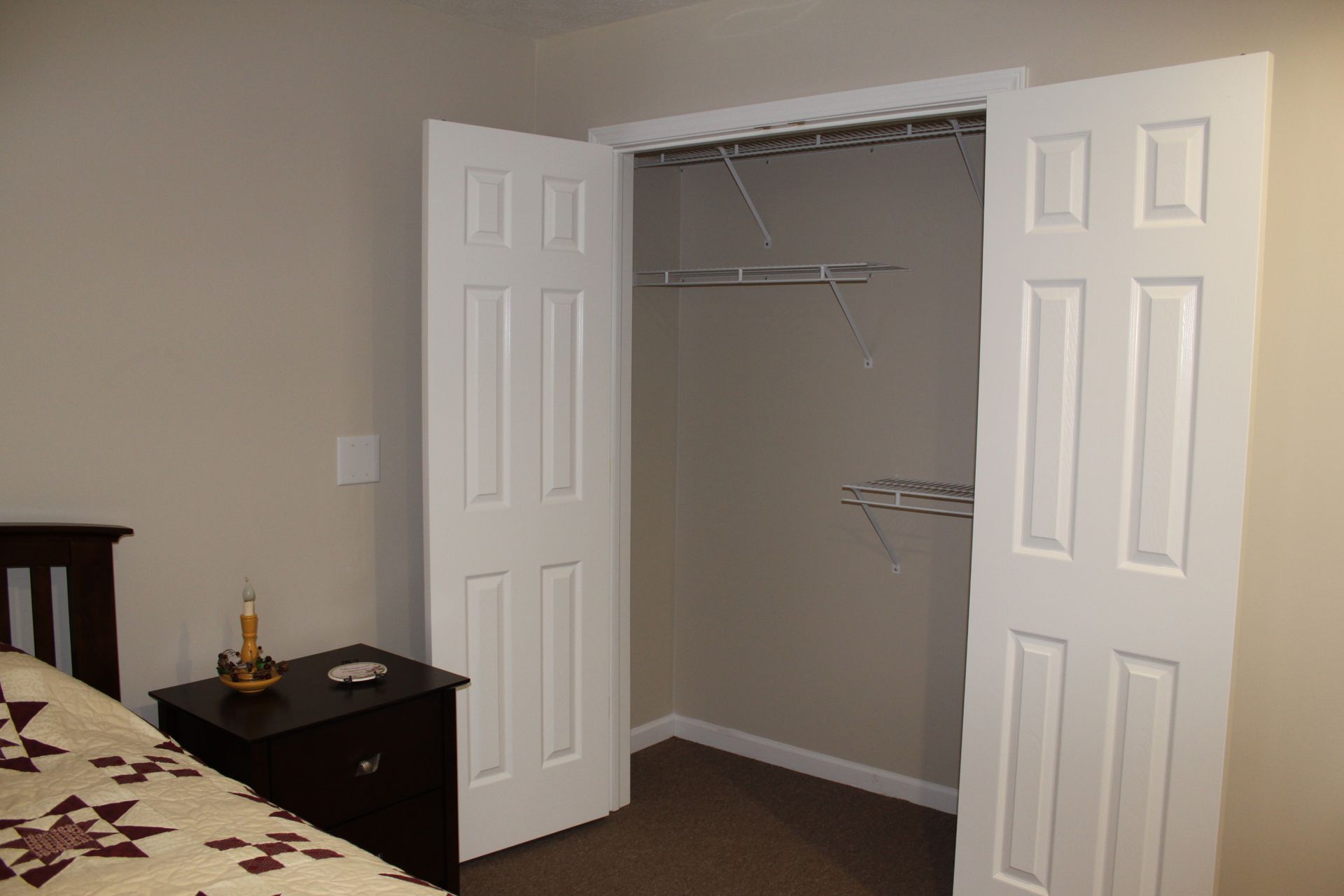 Gazebo in a landscaped garden with a brick building in the background.