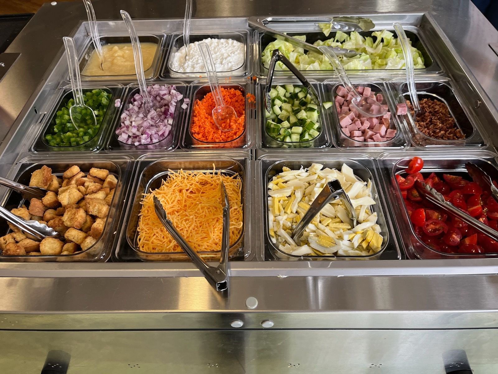 Gazebo in a landscaped garden with a brick building in the background.