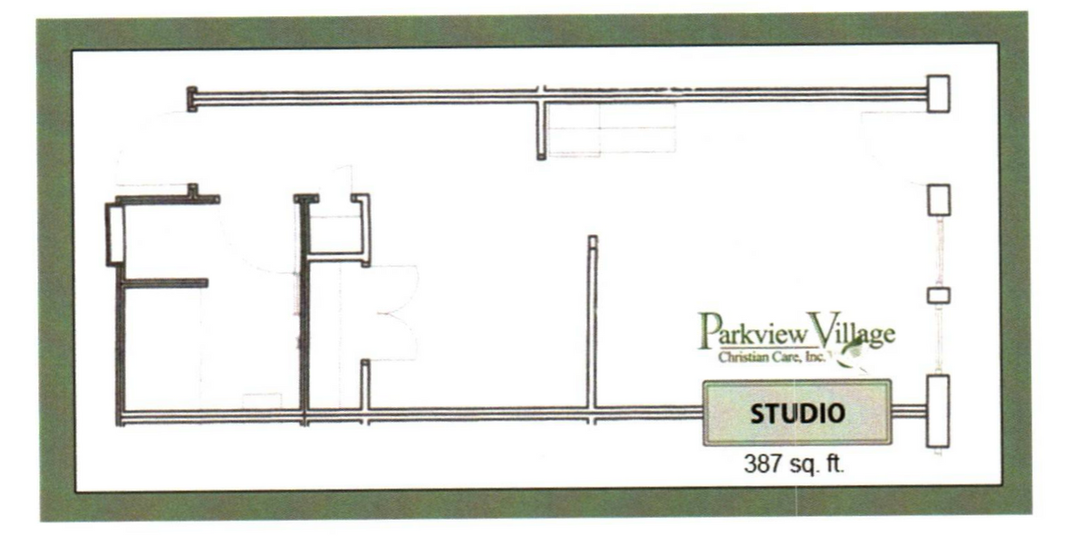 Rainbow arches over a residential area with a brick building and parked cars.