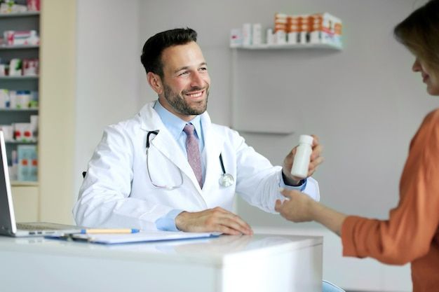 Pharmacist handing medication to a patient at a pharmacy counter.
