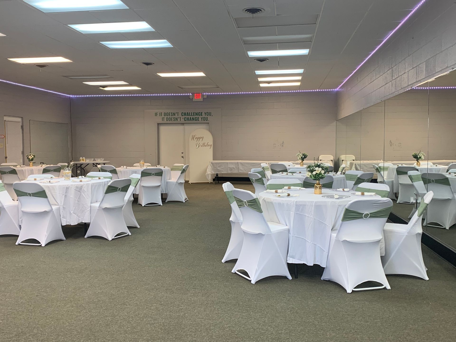 Our Dance Studio with round tables covered in white linens and white chairs with green sashes.