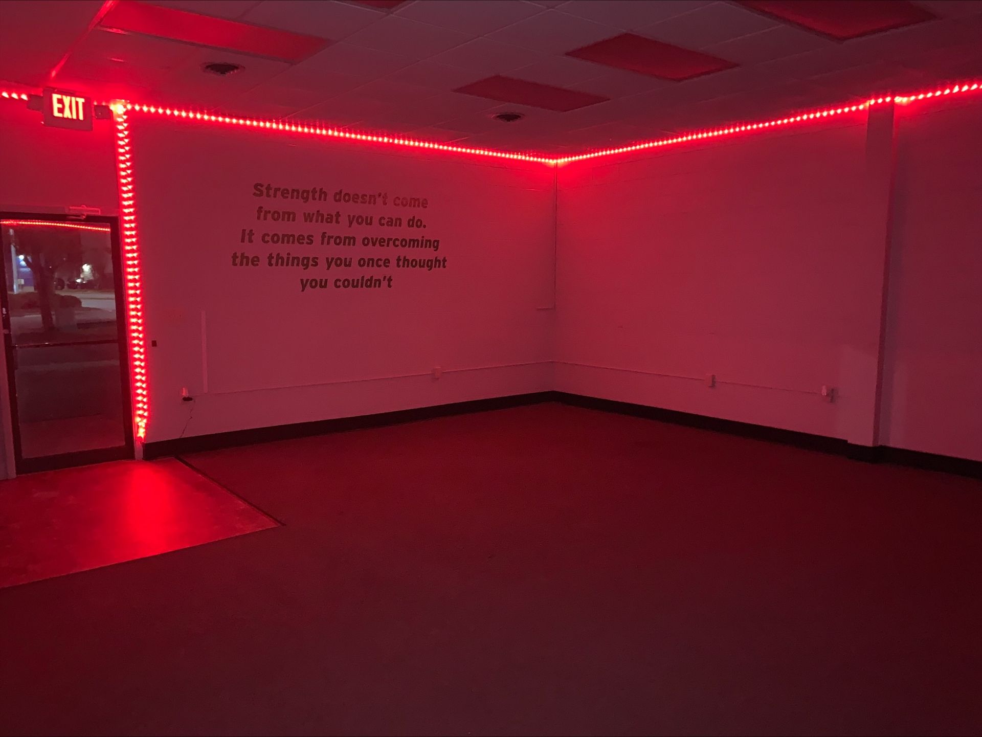 An empty room with red lights on the walls and ceiling