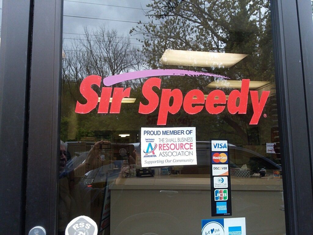 The front door of a store called sir speedy