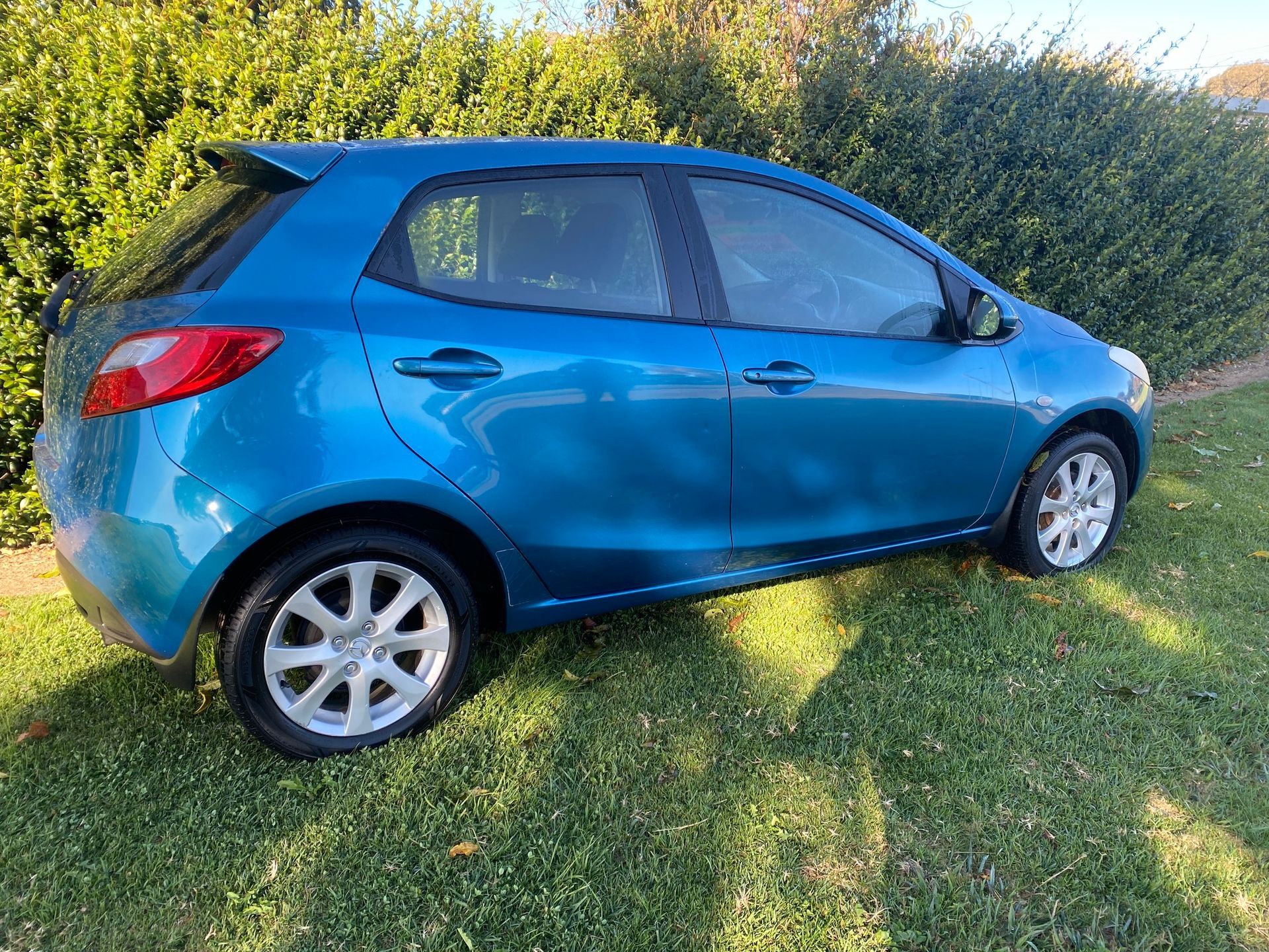 Blue Mazda 2 Hatchback Parked on Green Grass — Great Western Auto Wreckers in Orange, NSW