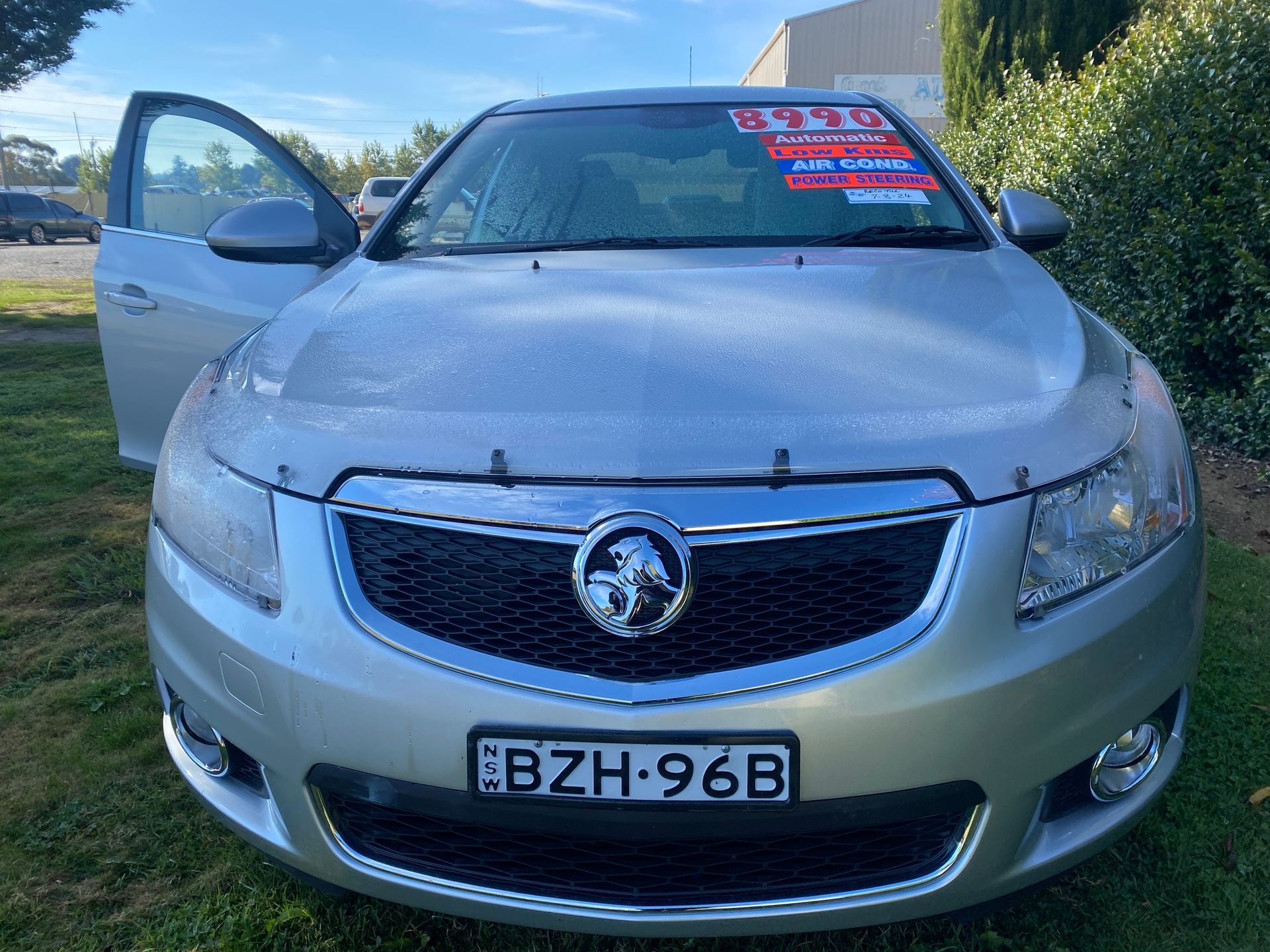 Silver Holden Car With Open Door Parked on Grass — Great Western Auto Wreckers in Orange, NSW