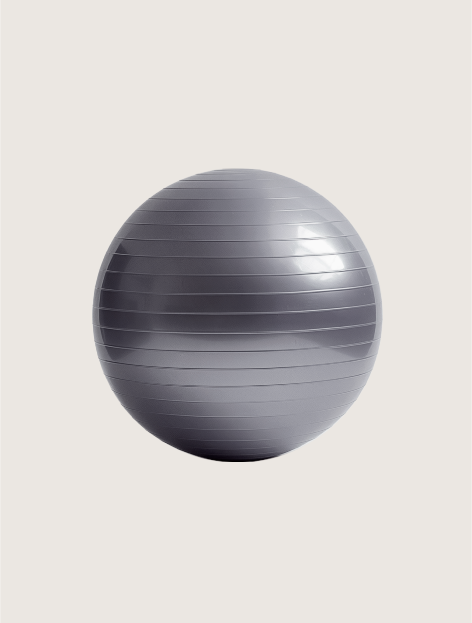 A gray exercise ball is sitting on a white surface.