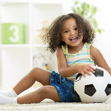 A girl is holding a soccer ball