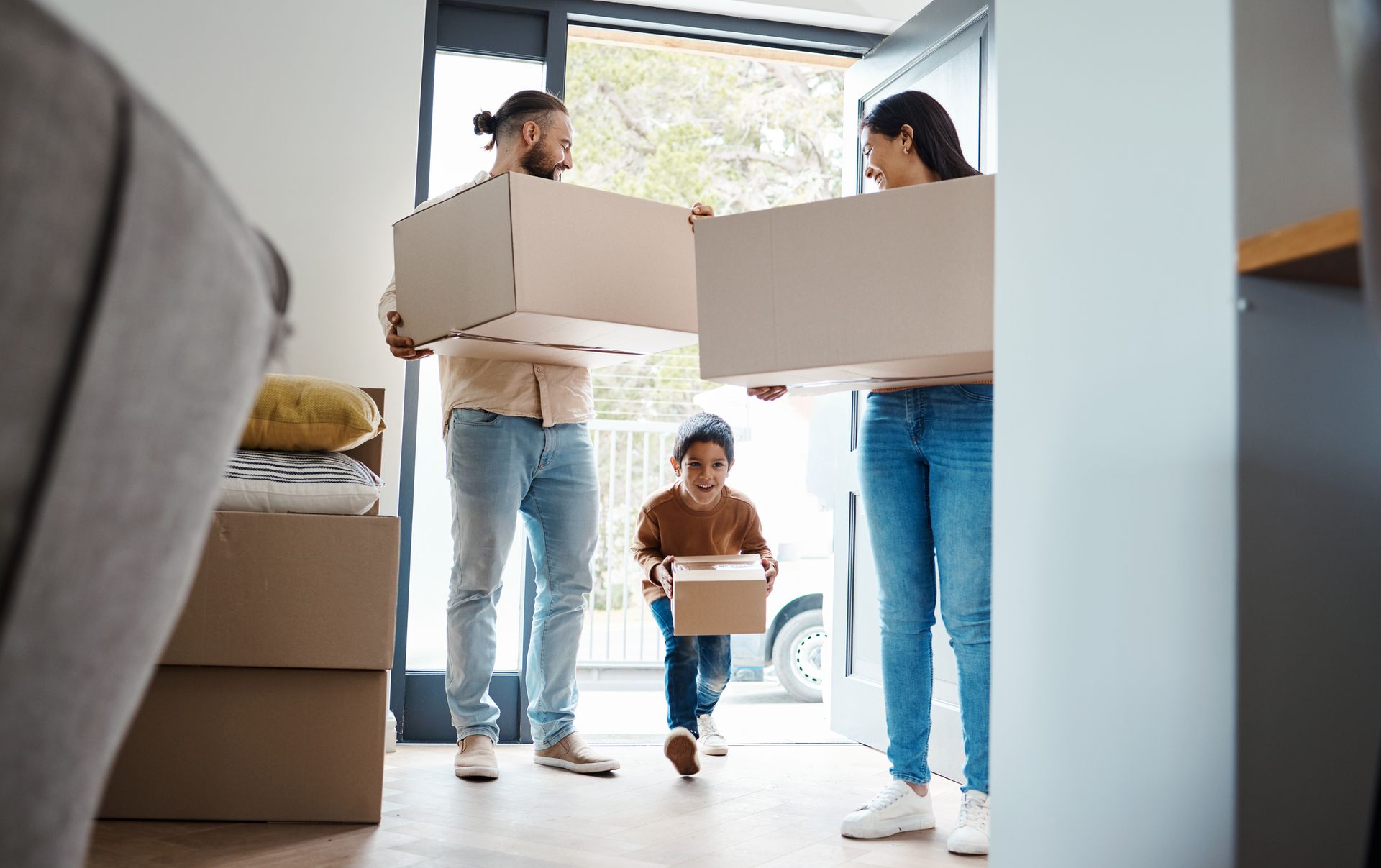 A family is carrying boxes into a new home.