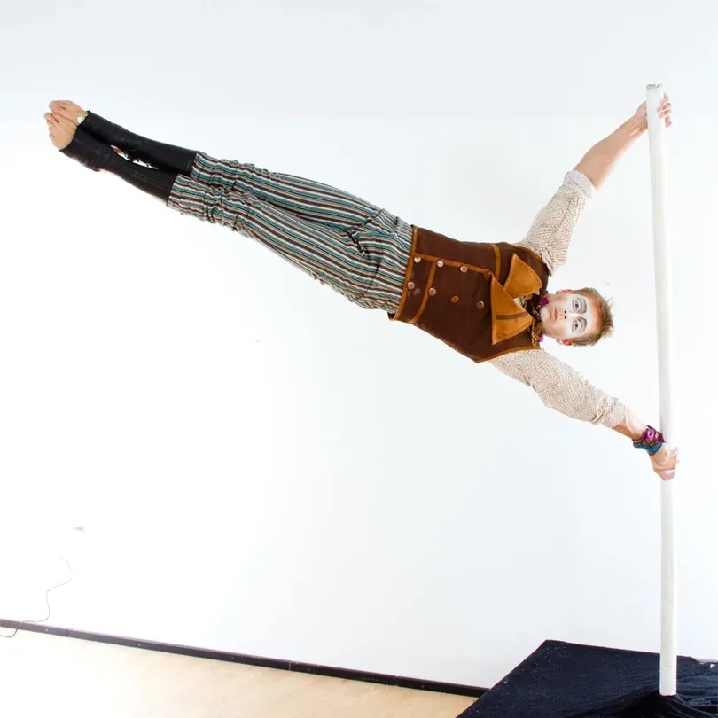 Milanus Circus, Miami, FL, pole performer, legs extended.