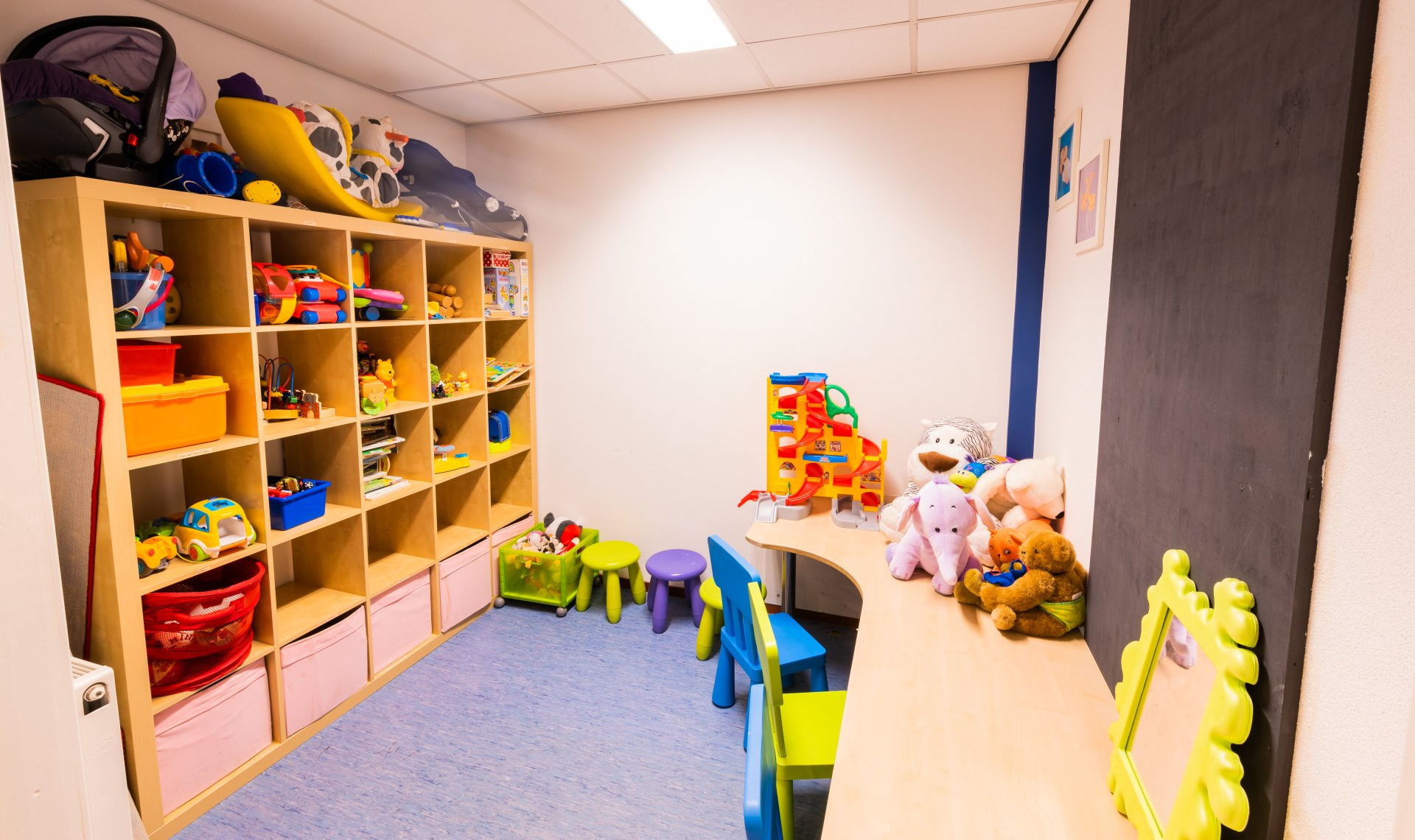 Een kamer vol met veel knuffels en speelgoed