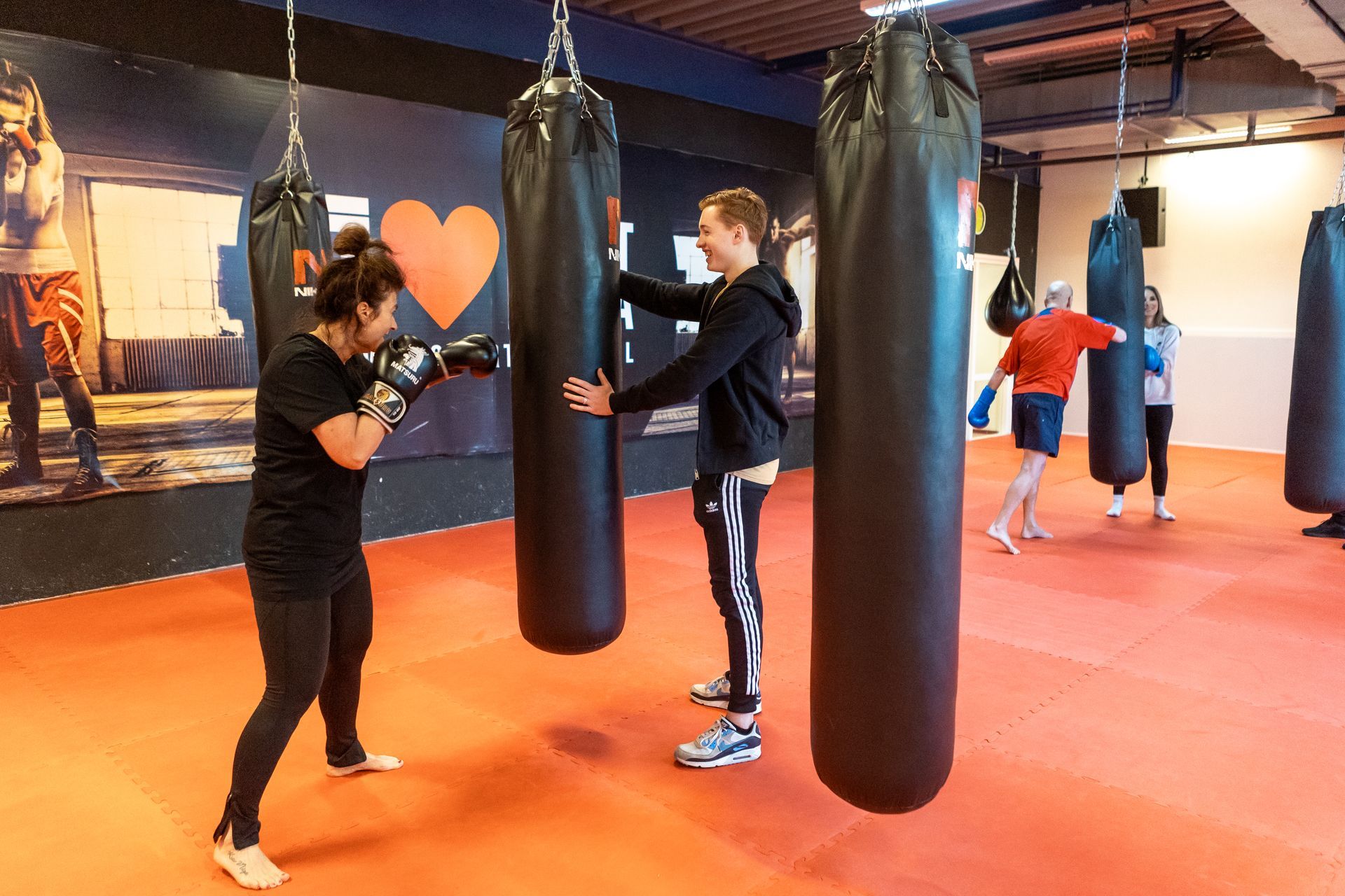 Een groep mensen is aan het boksen in een sportschool.