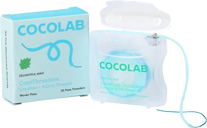 A light blue box and a clear plastic dispenser of COCOLAB CocoThreaders dental floss on a white background.