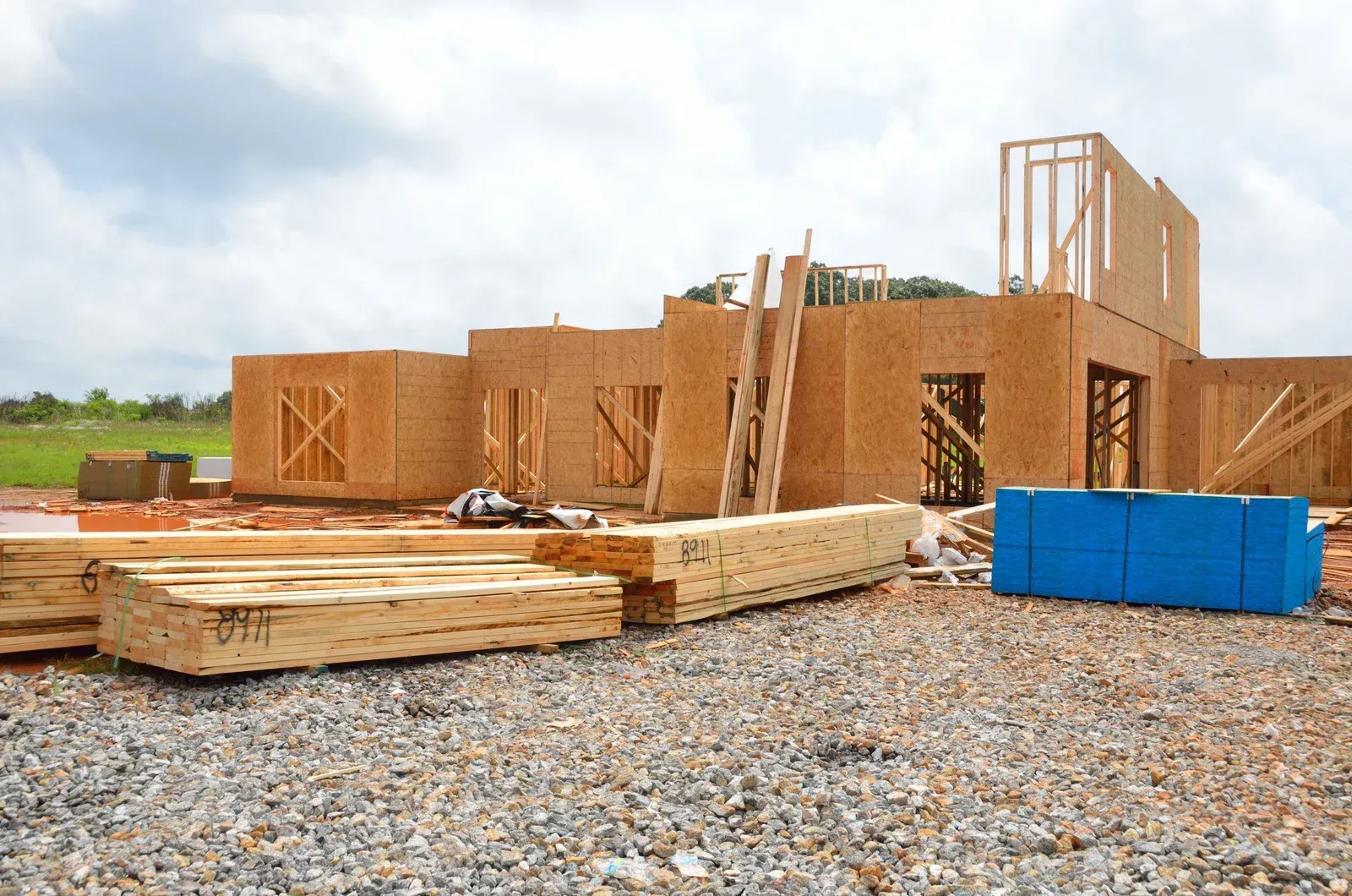 A house is being built on a gravel lot.
