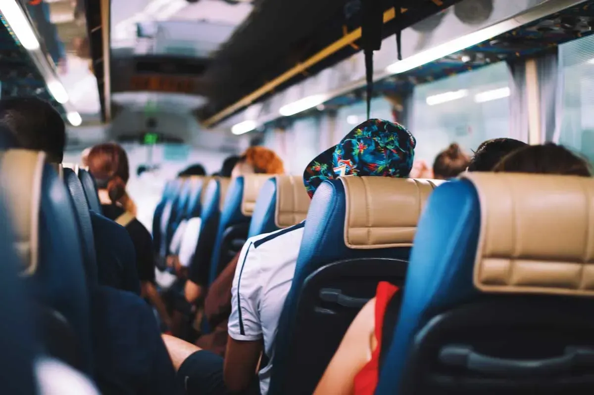 Um grupo de pessoas está sentado em um ônibus.