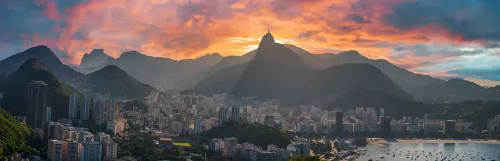 Uma vista aérea da cidade do Rio de Janeiro, ao fundo o pôr do sol.
