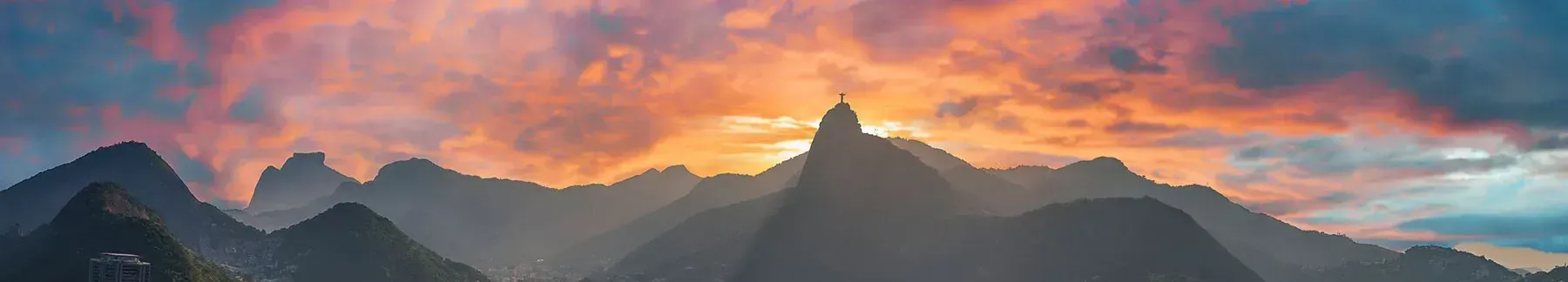 Uma vista aérea da cidade do Rio de Janeiro, ao fundo o pôr do sol.