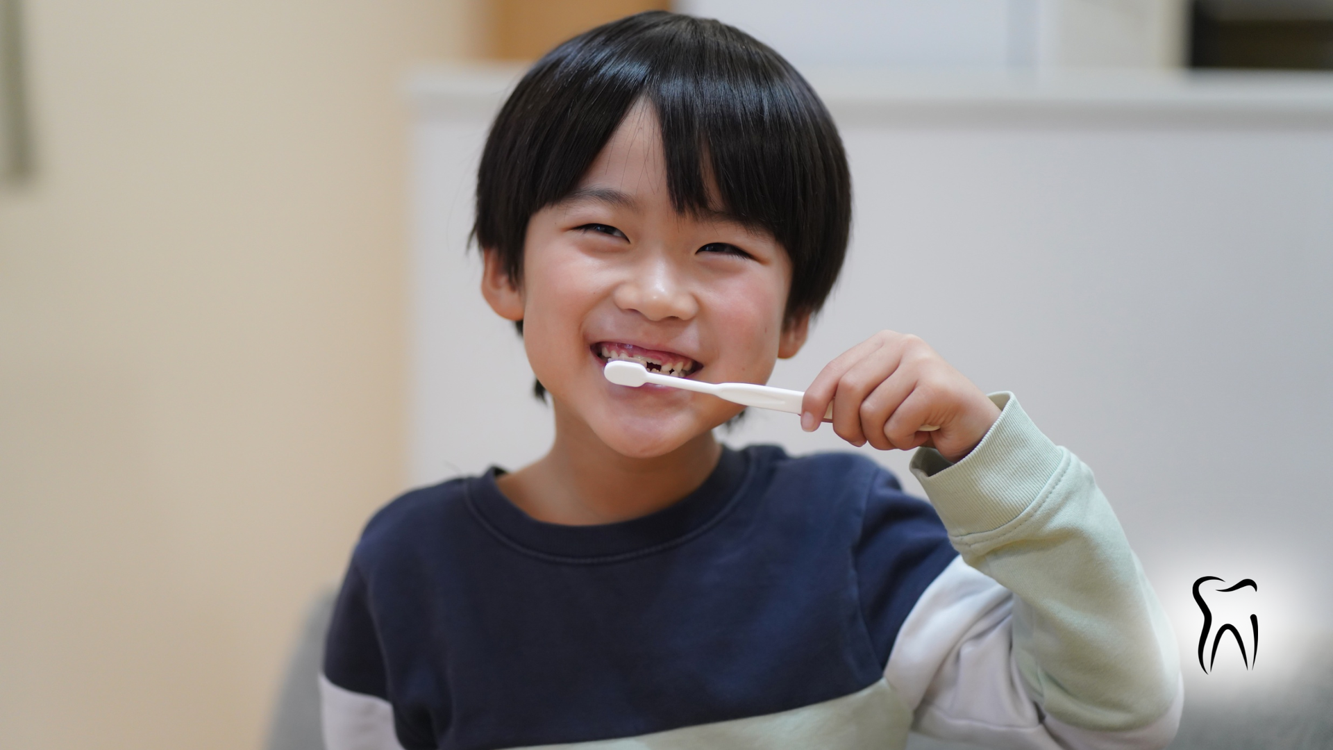 Boy brushing his teeth, smiling, indoors.