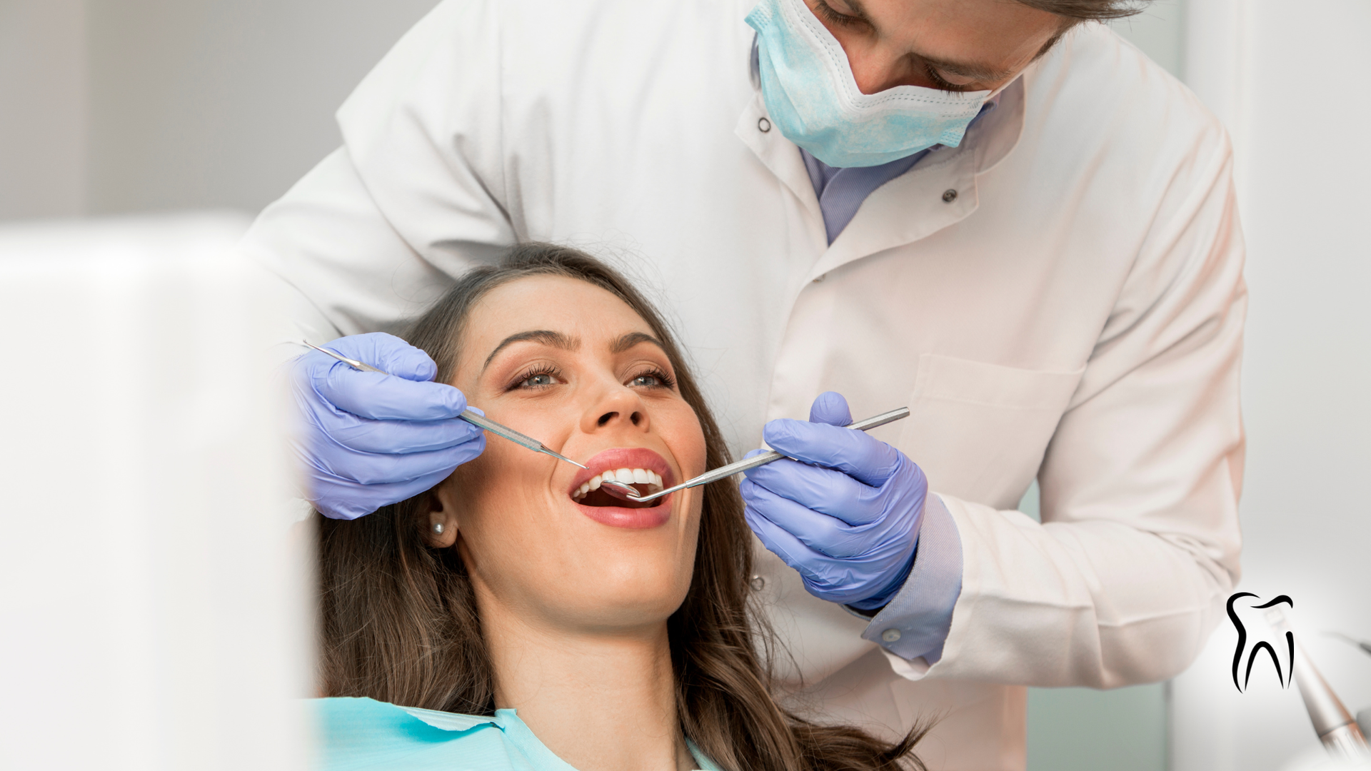 Dentist examining a patient's teeth. The patient is sitting in a chair, mouth open. The dentist wears a mask and gloves.