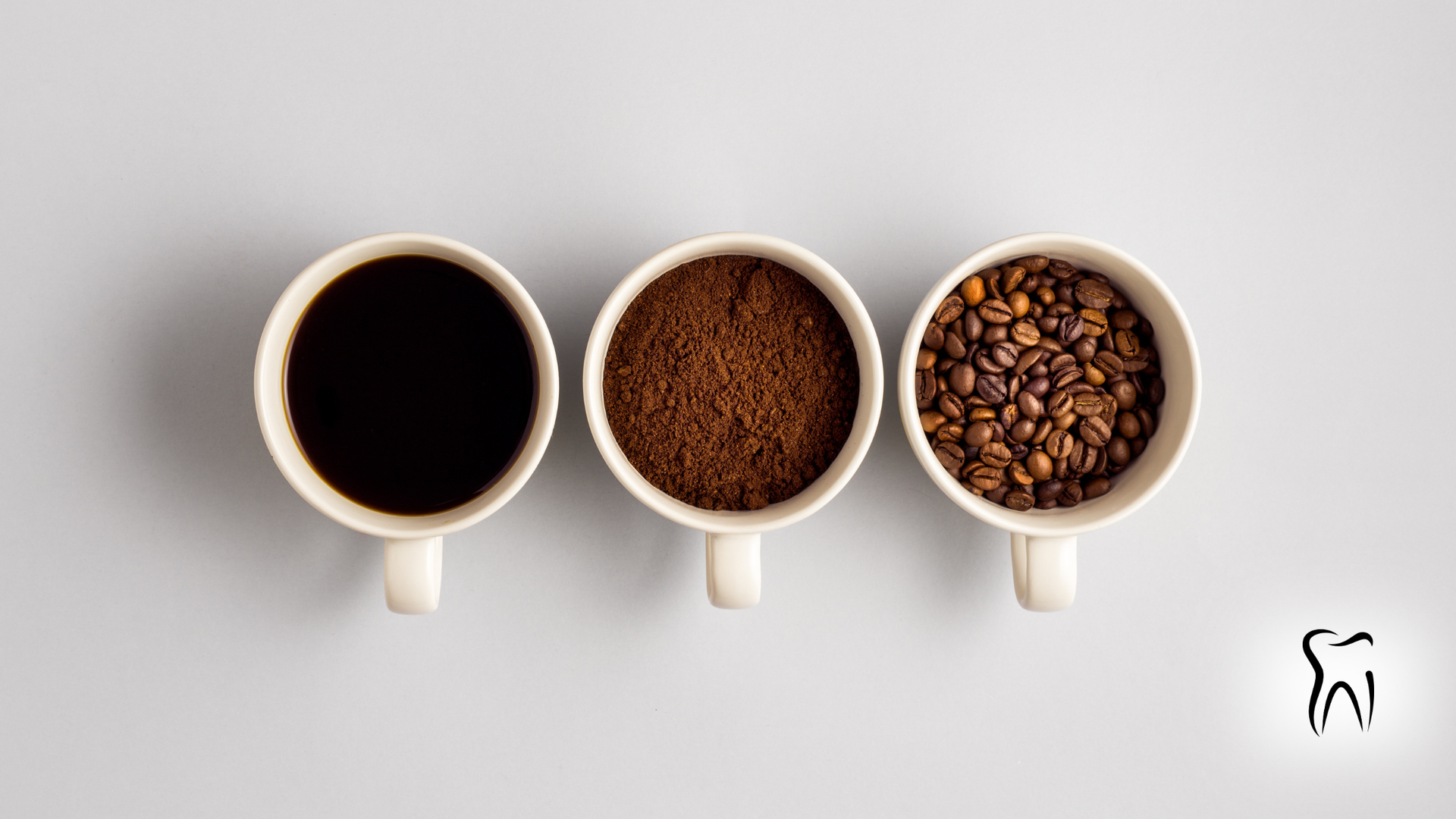 Three mugs: coffee, grounds, and beans on a gray background. A dental logo is in the bottom right corner.