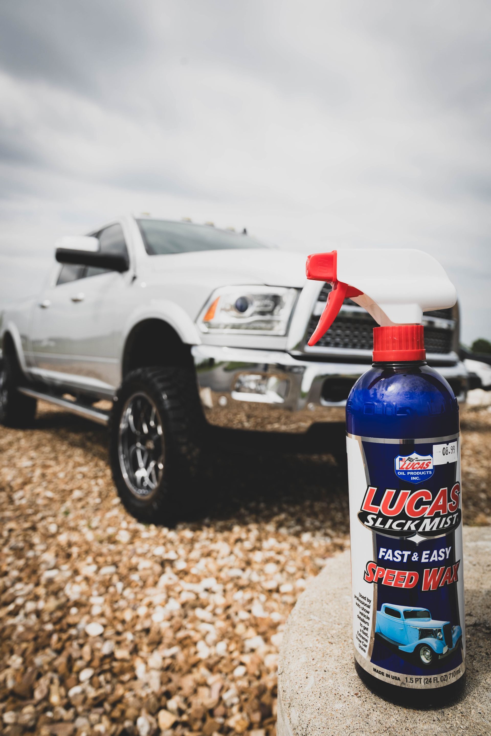 Lucas Slick Mist spray bottle in front of a white pickup truck on gravel. | Mountain Top Service Center