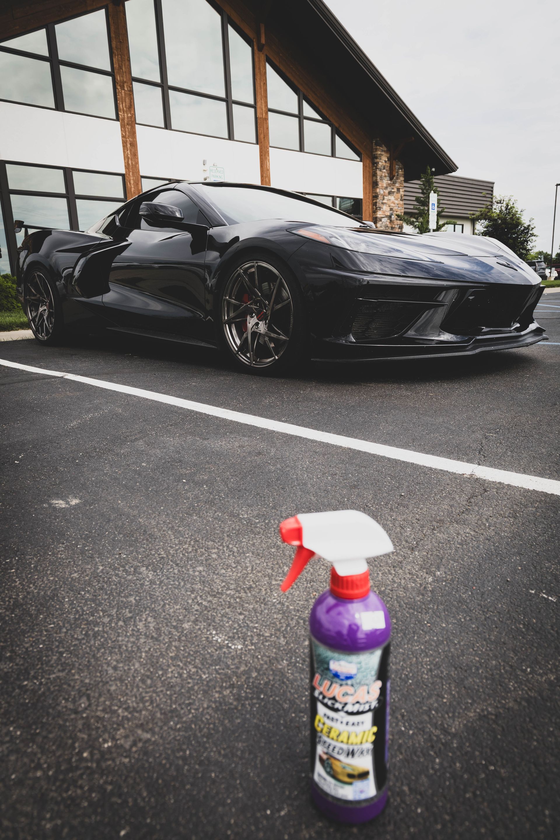 Black Corvette sports car parked; spray bottle in foreground. | Mountain Top Service Center