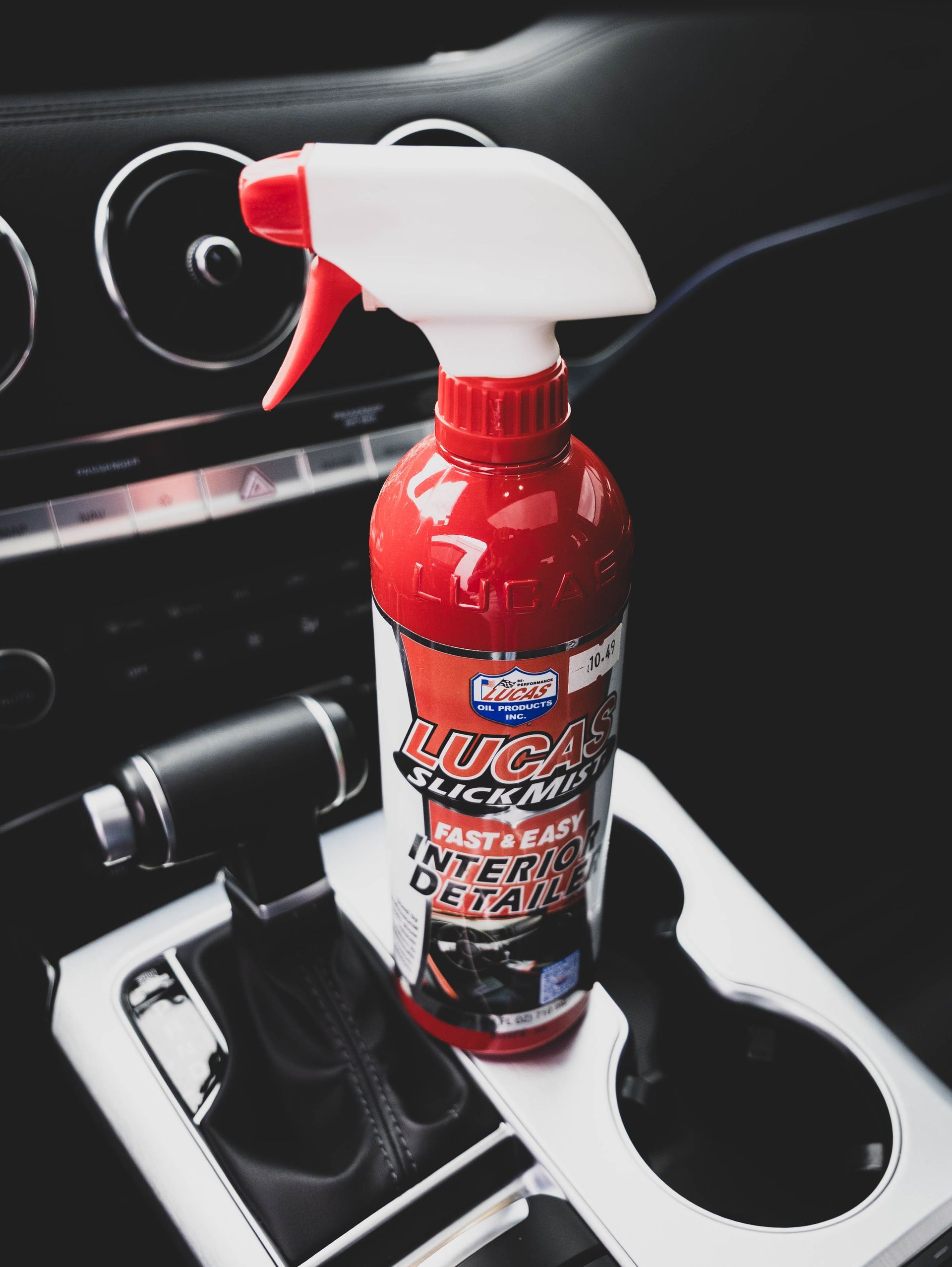 Red Lucas car interior detailer spray bottle in a car's center console. | Mountain Top Service Center