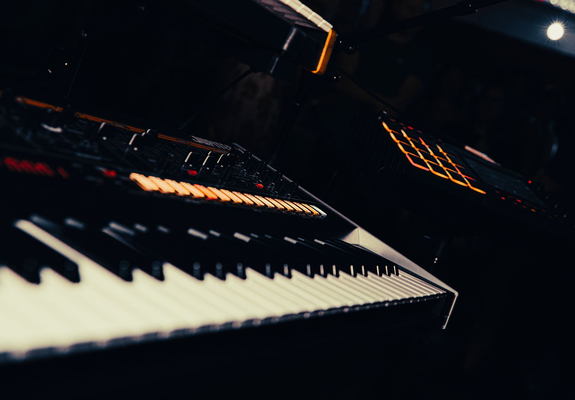 Keyboard and other electronic music equipment, dimly lit stage.