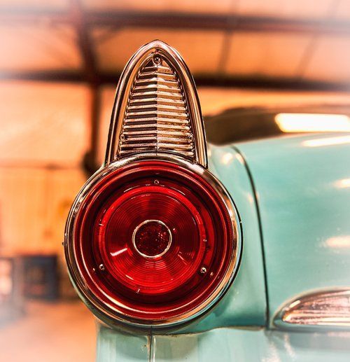 Close-up of a classic blue car tail light with a red lens and chrome trim.
