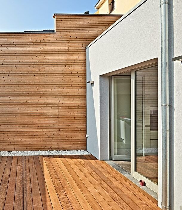 A House With A Wooden Deck In Front Of It — Chris Stolk Constructions In Corrimal, NSW