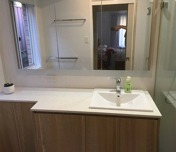A Bathroom With A Sink And A Large Mirror — Chris Stolk Constructions In Kanahooka, NSW