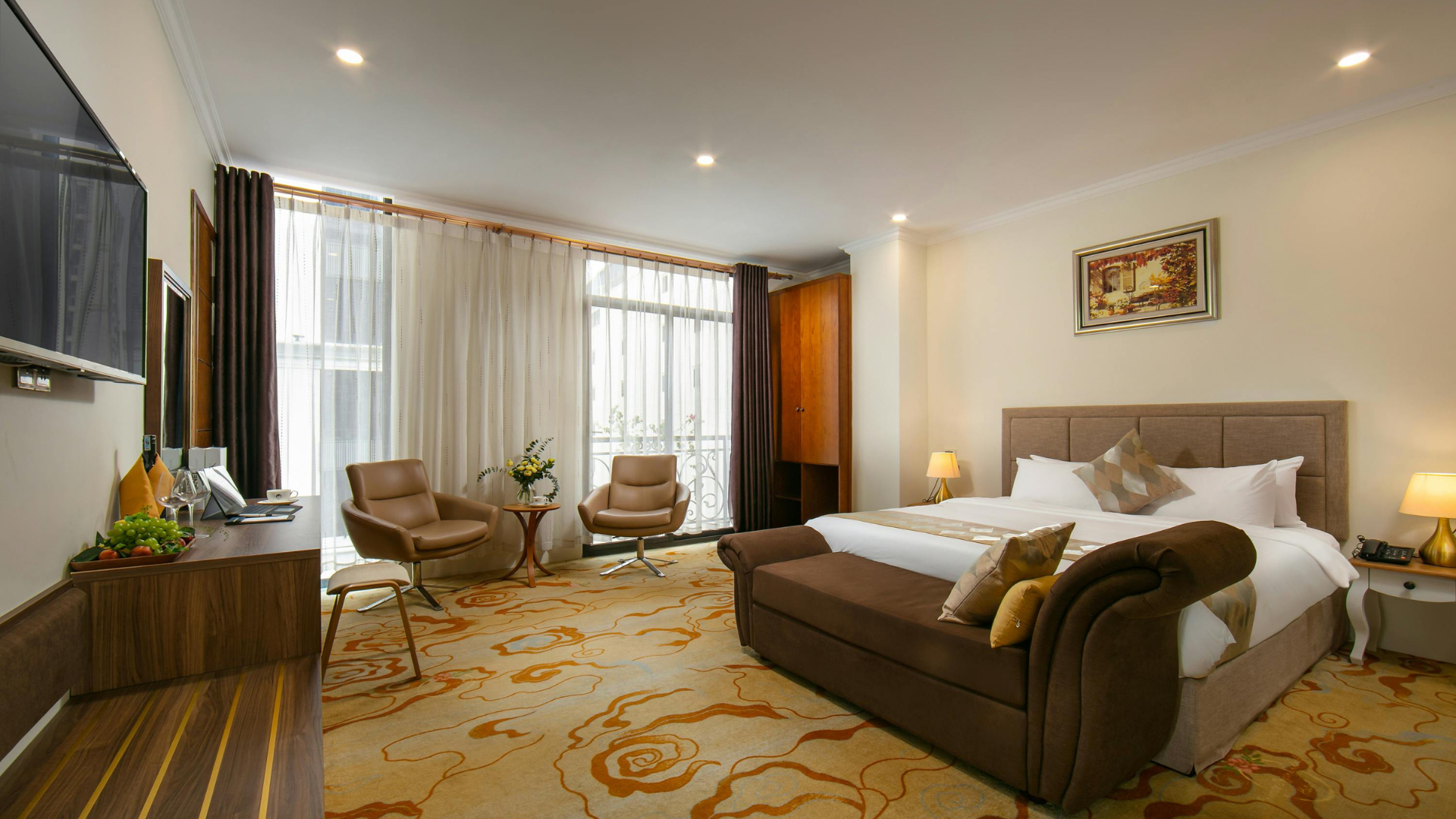 A hotel room with a large bed , couch , chairs and television.