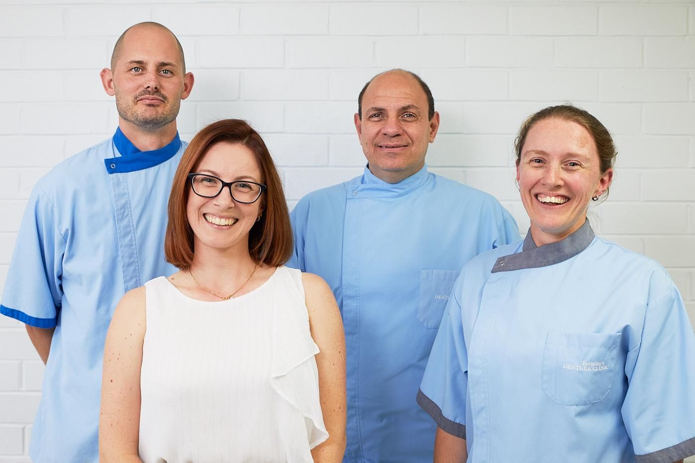 A Group of Dentists Are Posing for a Picture Together — Bromley's Denture Clinic in Tweed Heads South, NSW
